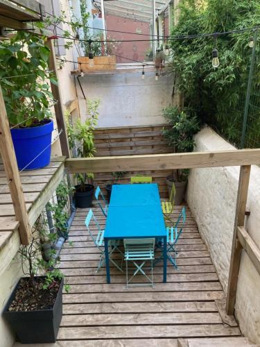 une table bleue et des chaises sur une terrasse agrémentée de plantes dans l'établissement appartement coeur de Montpellier, à Montpellier