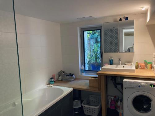 La salle de bains est pourvue d'une baignoire, d'un lavabo et d'un lave-linge. dans l'établissement appartement coeur de Montpellier, à Montpellier