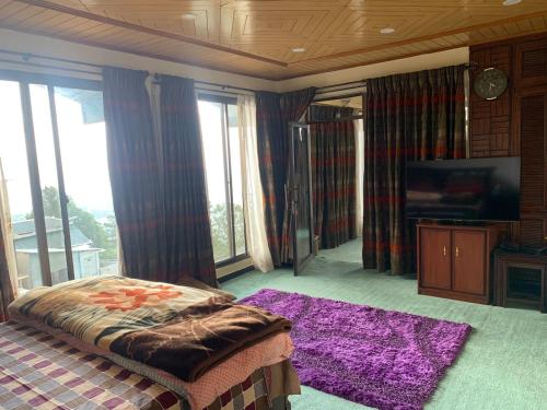 マリーにあるMalika Kohsar Hotel Murreeのベッドとテレビと窓のある寝室