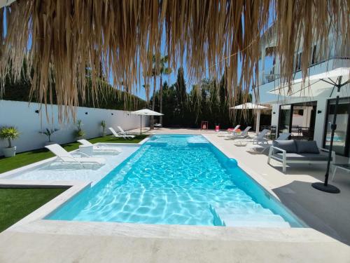 Una piscina con sillas y un edificio. en Five Palms Villa, en Paphos