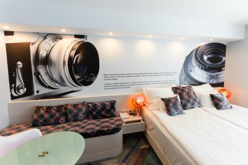 a room with a bed with a camera on the wall at Science Hotel Prémium in Szeged