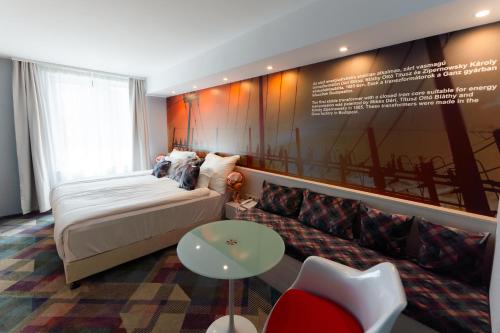 a hotel room with a bed and a couch at Science Hotel Prémium in Szeged
