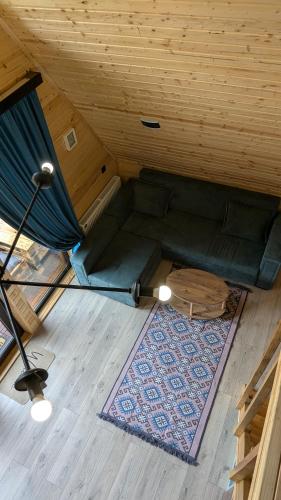 a living room with a couch and a rug at Rest point cottage Kazbegi in Stepantsminda
