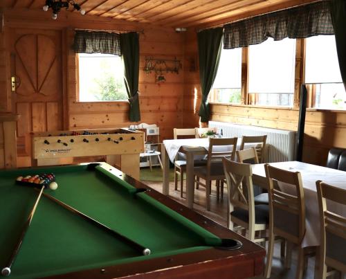 a pool table in a room with tables and chairs at Willa Stożek, 50 m od term i wyciągów narciarskich in Białka Tatrzanska
