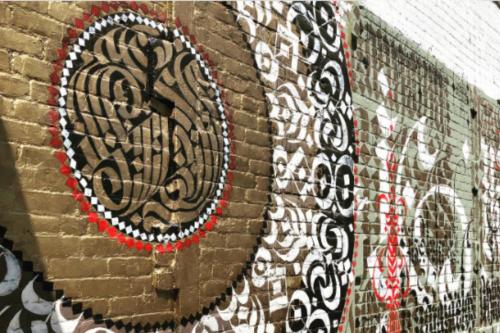 a brick wall with graffiti on it at American Hotel in Los Angeles