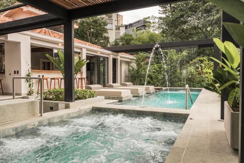una piscina en una casa con una fuente en Nattivo Luxury Home Medellin, en Medellín