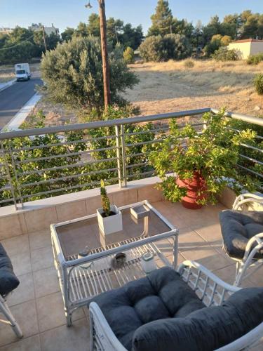 a patio with a couch and a table on a balcony at Homey Family ArtAki in Néa Artáki