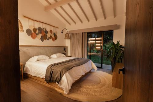 Un dormitorio con una cama y una ventana grande. en Nattivo Luxury Home Medellin, en Medellín