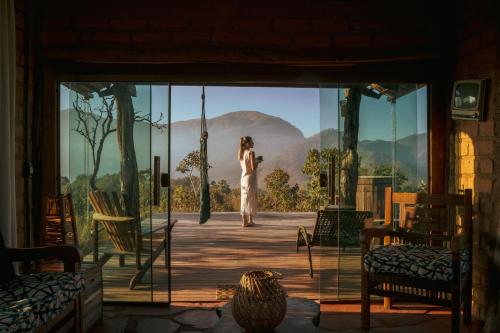 a woman standing on a stage with a view at Ecopousada Toca do Guará in Alto Paraíso de Goiás