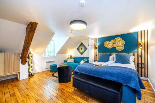 a bedroom with a blue bed and a couch at La Tanière du Roi - Versailles - à 10 min du Château et de la gare in Versailles