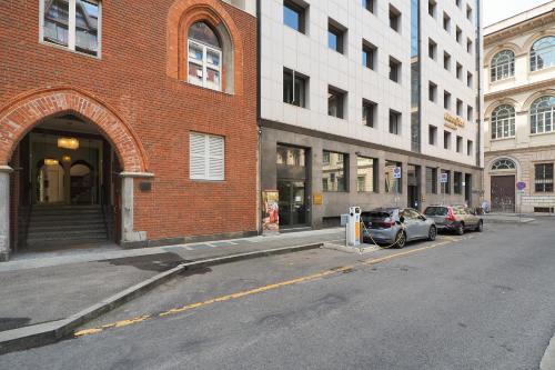 a street with cars parked in front of a brick building at Missori Luxury Apartments in Milan