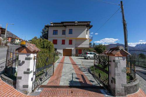 a gate to a house with mountains in the background at Il Panorama di Forster in Menaggio