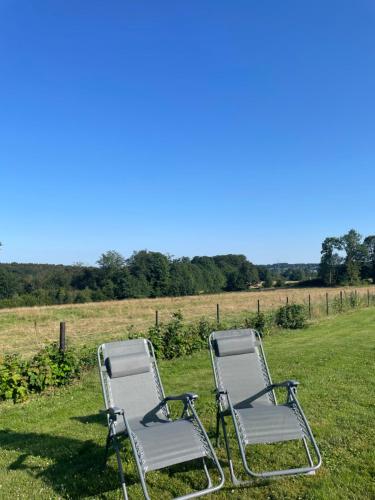 two chairs sitting in the grass in a field at Le Daguet in Florenville