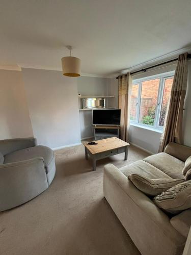 a living room with a couch and a table at Milton Keynes Comfort Haven in Haversham