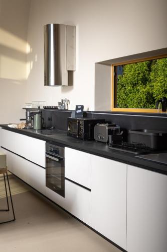 a kitchen with white cabinets and a black counter top at Nine Olives Hvar in Stari Grad