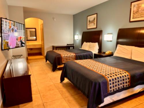a hotel room with two beds and a tv at Texas Inn and Suites City Center at University Dr. in Edinburg