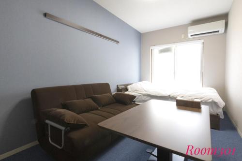 a living room with a couch and a table at SLEEPLAB THE STAY Casual 西新宿 in Tokyo
