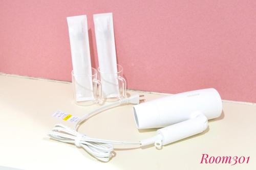 a white stethoscope on a table next to a pink wall at SLEEPLAB THE STAY Casual 西新宿 in Tokyo