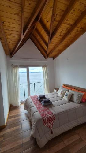 a bedroom with a large bed with a wooden ceiling at Departamento Ushuaia in Ushuaia