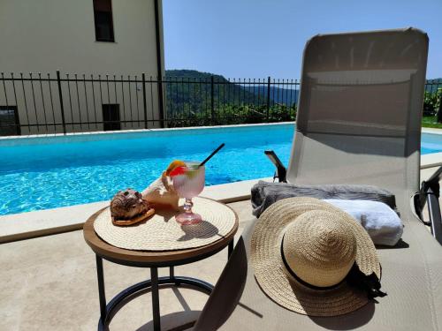 a hat and a table with a drink on a patio at Villa Lea Marezige Heated Pool near Koper in Marezige