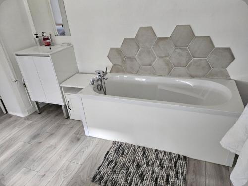 une salle de bain blanche avec une baignoire et un lavabo dans l'établissement Ma location plage dunkerque, à Dunkerque