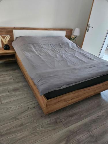 a large bed in a bedroom with a wooden floor at Ma location plage dunkerque in Dunkerque