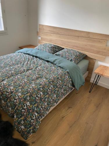 une chambre avec un lit avec une tête de lit en bois dans l'établissement Portet - Appartement 1, à Portet-sur-Garonne