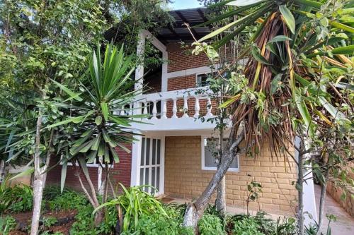 a brick house with palm trees in front of it at Casa Flores de la Montaña in Mineral del Monte