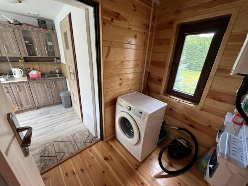 a washer and dryer in a log cabin at Wakacyjny domek - Łaś Ogrody in Rzewnie
