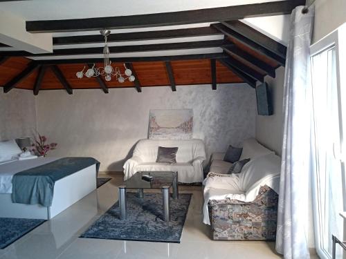 a room with a bed and a couch and a table at Moravska Obala - Prenoćište i Restoran in Velika Plana