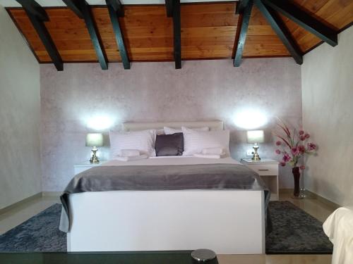 a bedroom with a large white bed with two lamps at Moravska Obala - Prenoćište i Restoran in Velika Plana