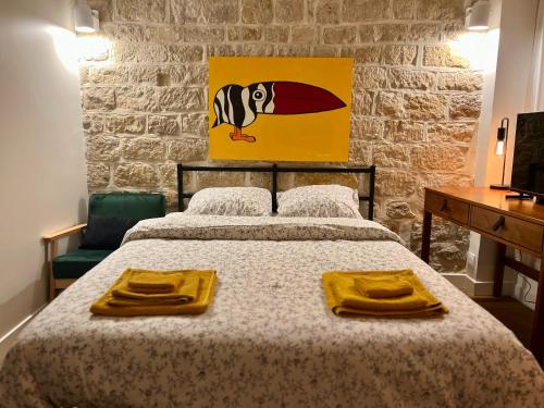 - une chambre avec un lit et des serviettes jaunes dans l'établissement Studio des Tuileries, à Paris