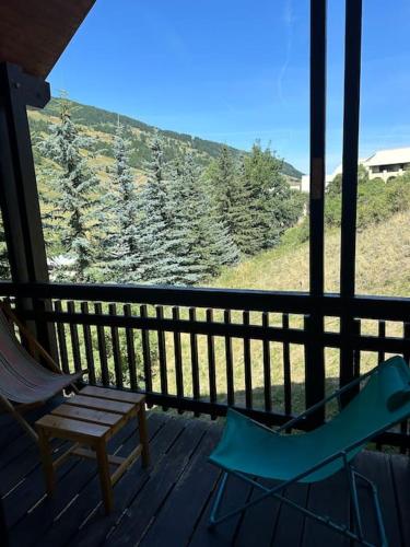 a porch with a chair and a bench on a deck at Duplex a l'hostellerie in Vars