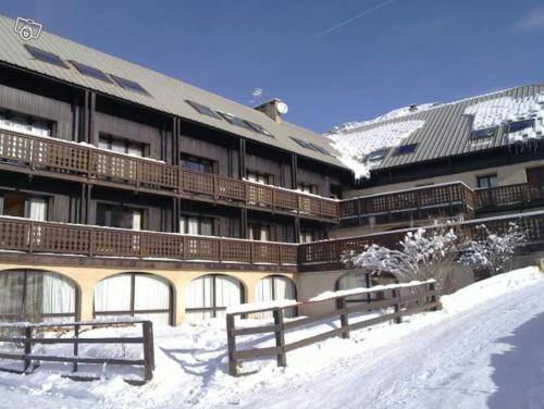 a large building with snow in front of it at Duplex a l'hostellerie in Vars