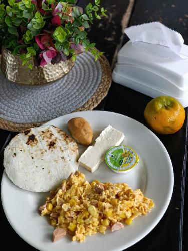 a plate of food with bread and cheese on a table at Colina del Sol Hotel Hacienda in Quimbaya