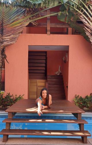 a woman laying on a table in front of a house at Pousada Arraial Inn in Arraial do Cabo