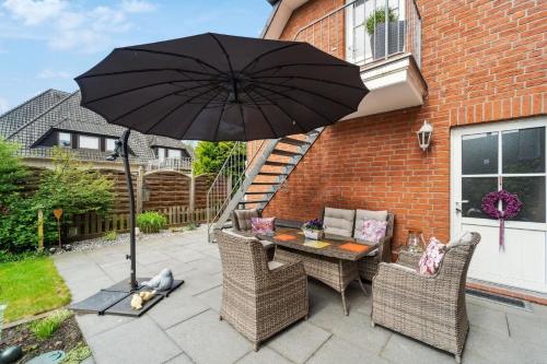 a table and chairs with an umbrella on a patio at Ferienwohnung in Ottersberg mit Eigener Terrasse in Ottersberg
