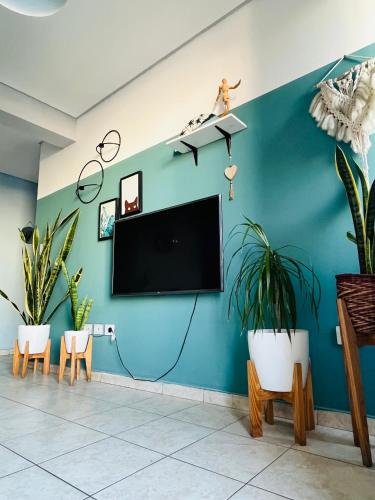 a living room with a tv on a blue wall at Altos de Barrio Sur in San Miguel de Tucumán