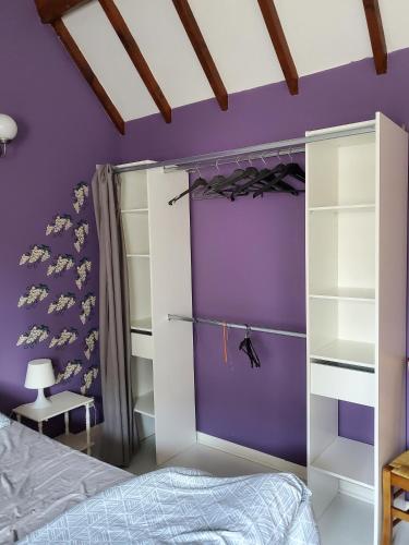 a purple bedroom with a bed and a purple wall at Gîte des peupliers, gîte à la ferme in Rebergues