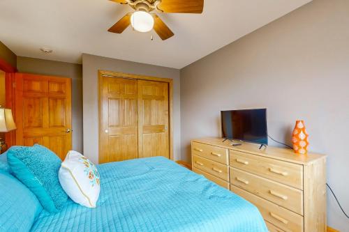 a bedroom with a blue bed and a tv on a dresser at Sunset Condominiums: The View in Arkdale