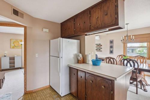 a kitchen with a white refrigerator and wooden cabinets at Stellar two bedroom home in Minneapolis