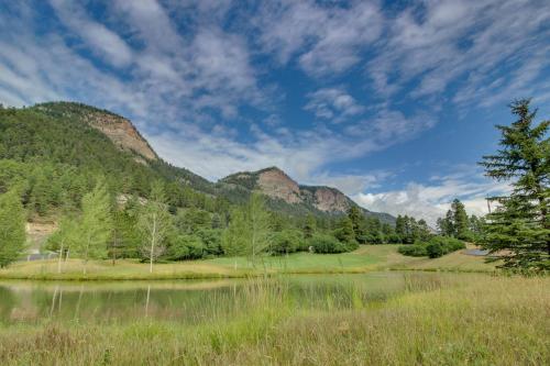 a field with a lake and mountains in the background at Tamarron Lodge in Durango