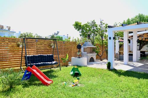 a backyard with a playground with a slide at Harmony Garden House in Ialyssos