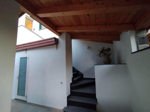 a hallway with stairs and a wooden ceiling at Rosetta home in Meta