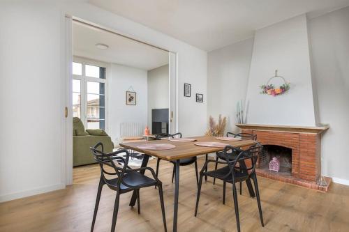 - une table et des chaises dans le salon doté d'une cheminée dans l'établissement Portet - Charmant T3, à Portet-sur-Garonne