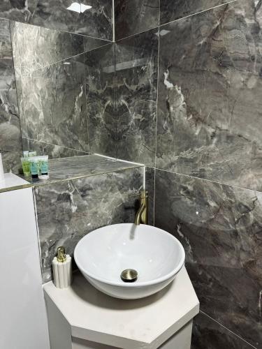 a bathroom with a sink and a marble wall at MSM Arena Hotel in London