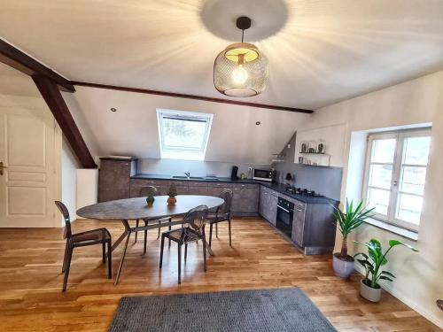 a kitchen with a table and chairs in a room at Appartement confortable à Bitche avec jacuzzi, 100 m². in Bitche