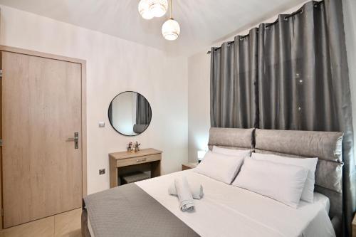 a bedroom with a large white bed with a mirror at Harmony Garden House in Ialyssos