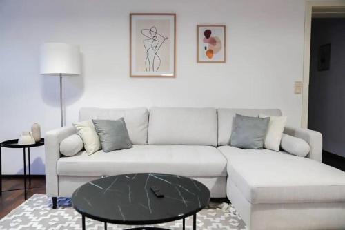 a living room with a white couch and a table at Authentic Austrian Flat in the South of Vienna in Mödling