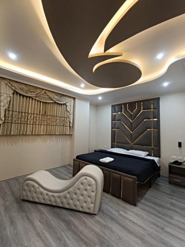 a bedroom with a bed and a couch in a room at Hostal Kapital City in Quito
